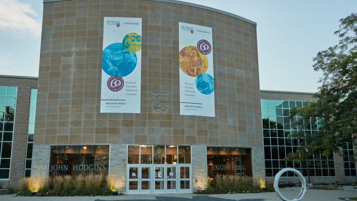 Two large banners hang across the front of the John Hodgins Engineering building,