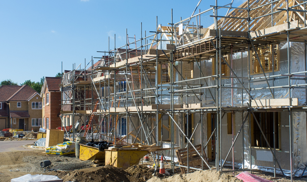 A row of townhouse being built. Scaffolding stretches across the fronts of the units.